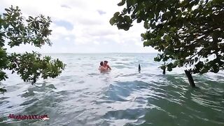 A couple makes love directly in the water of a stunning blue lagoon