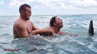 A couple makes love directly in the water of a stunning blue lagoon