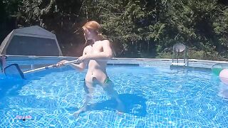 Redhead in red bikini dives in the swimming pool