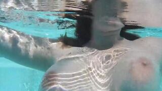 A sexy girl plays with dildo in the pool, trying not to show her tits