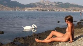 A hot girl is walking on the riverbank without any clothes