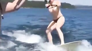 Topless girl rides on the water skiing