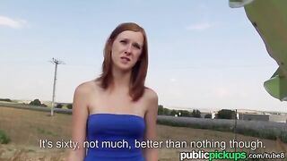 A red-haired girl is having fun on a hay pile