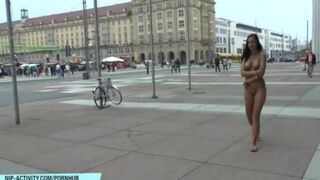 A young naked girl is walking on the city streets and showing her body