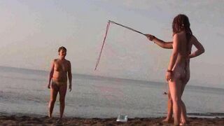 A naked girl is having fun on the sandy coast