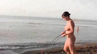 A naked girl is having fun on the sandy coast