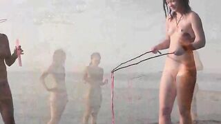 A naked girl is having fun on the sandy coast