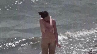 A couple of free-spirited lovers have fun on the nudist beach