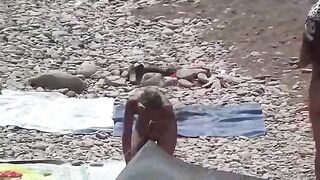 A couple of free-spirited lovers have fun on the nudist beach
