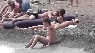 A couple of free-spirited lovers have fun on the nudist beach