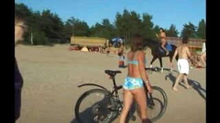 A topless beauty is having fun on the beach with others