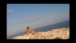The girl has a sunbath directly on the sandy coast in all her nakedness
