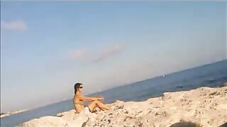 The girl has a sunbath directly on the sandy coast in all her nakedness