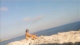 The girl has a sunbath directly on the sandy coast in all her nakedness
