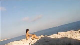 The girl has a sunbath directly on the sandy coast in all her nakedness
