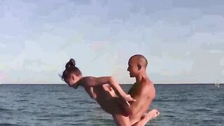 Nude beauties demonstrate their skills in acrobatics on the beach