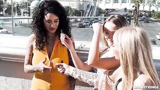 A pair of sexy girls are having fun on the strip, and another girl joins them